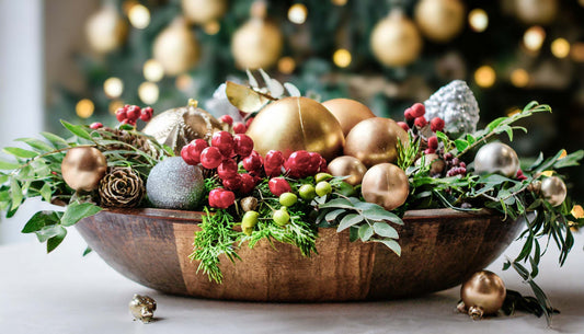 Wooden dough bowl filled with vintage holiday ornaments and greenery.