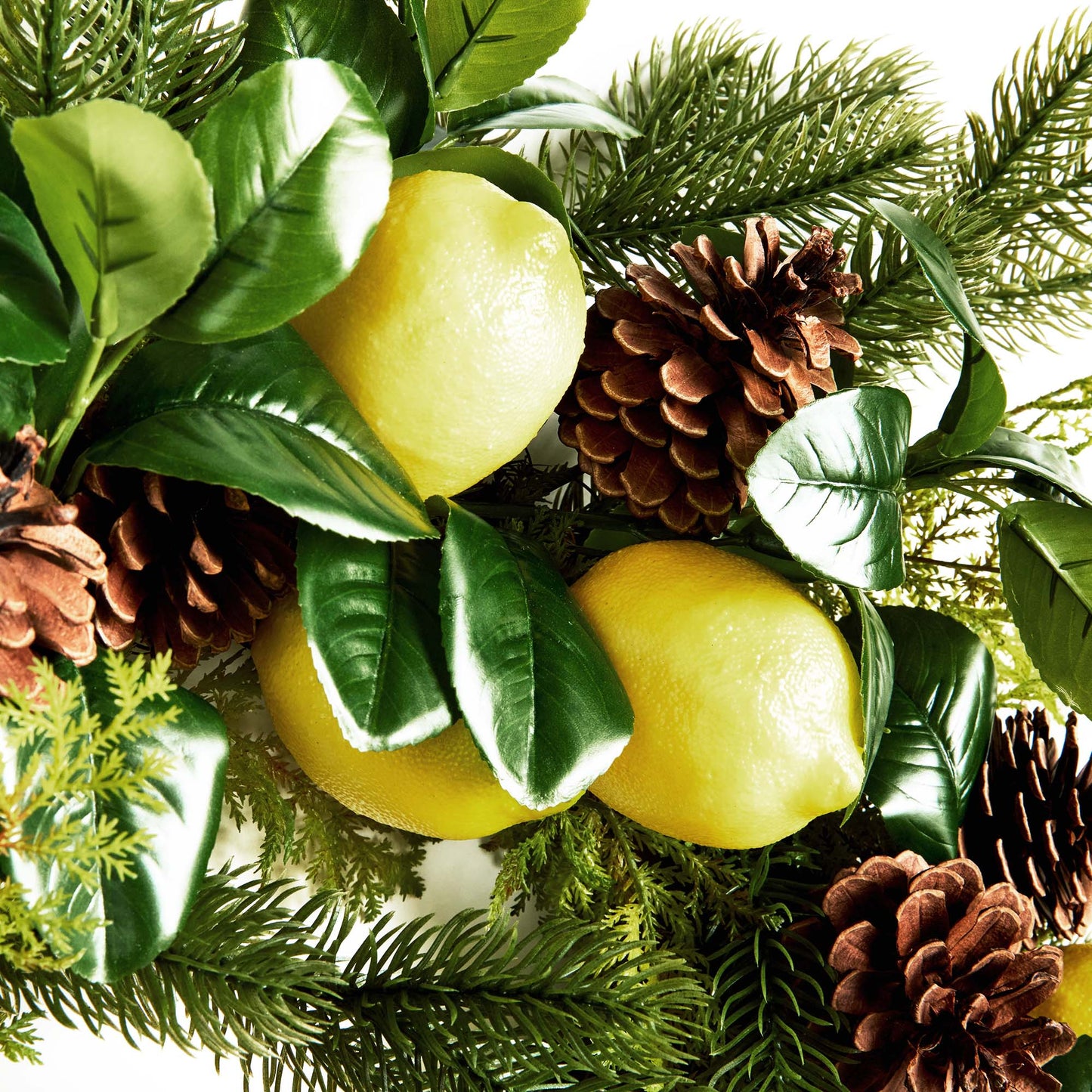 26" faux lemon and mixed botanicals wreath, closeup view, with gray background.