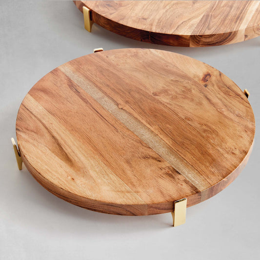 Acacia wood round serving board closeup view with gray background.