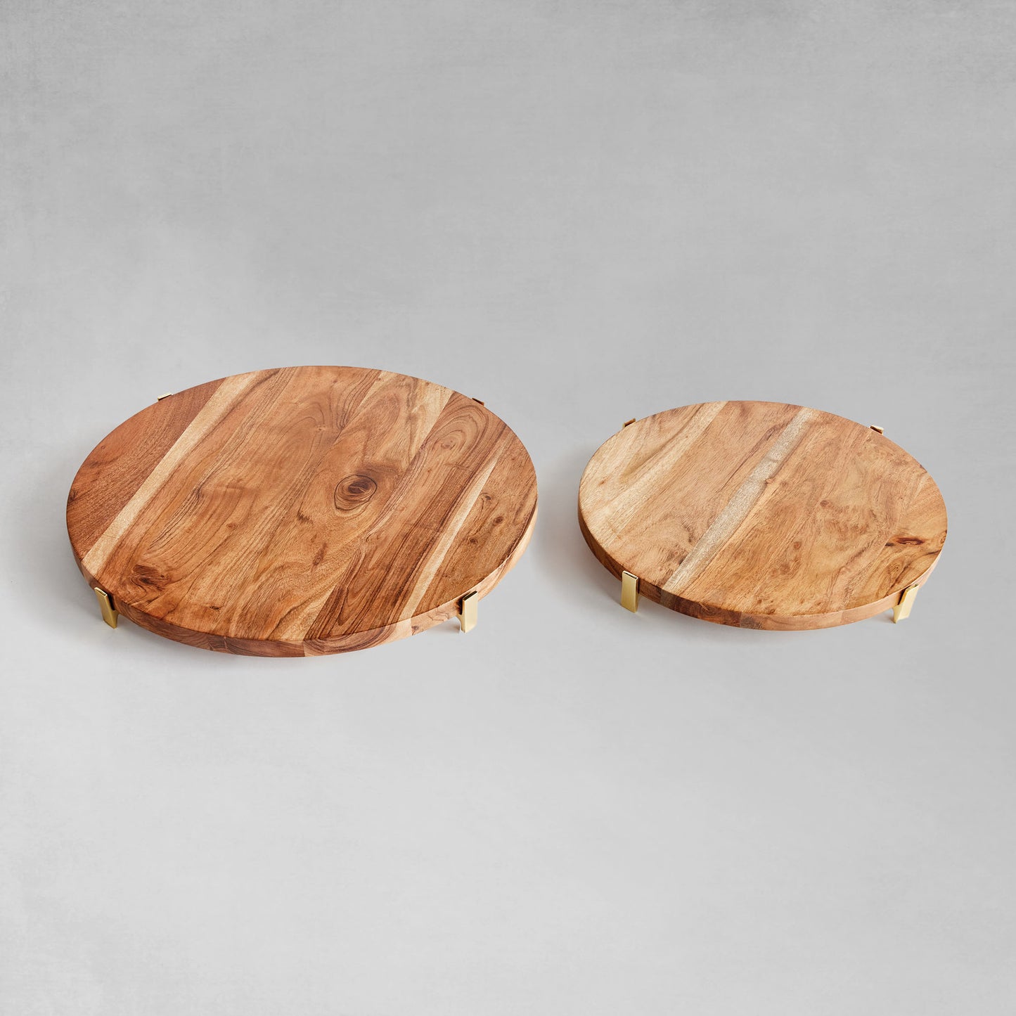 Acacia wood round serving board top view with gray background.