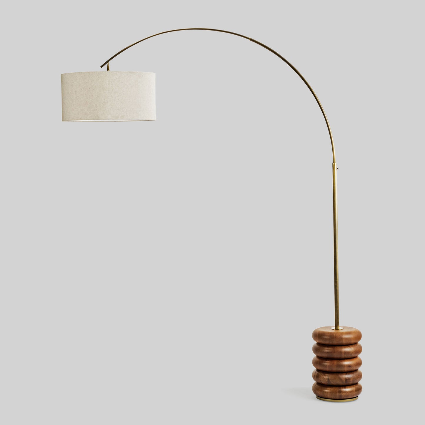 Floor lamp with a curved arm and wooden base on a light gray background.