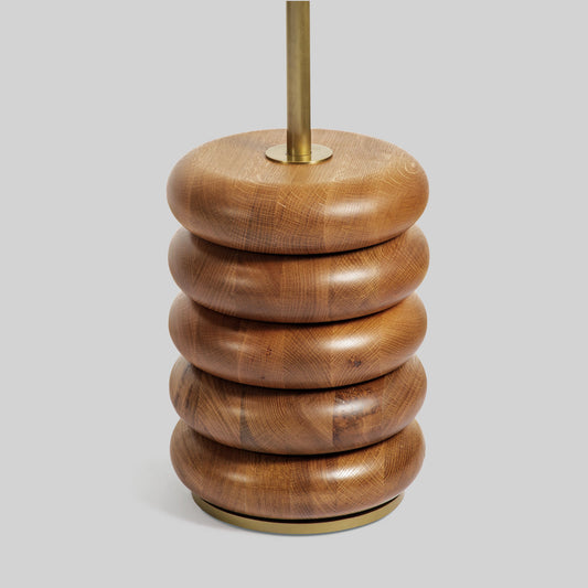 Floor lamp with a curved arm and wooden base on a light gray background.