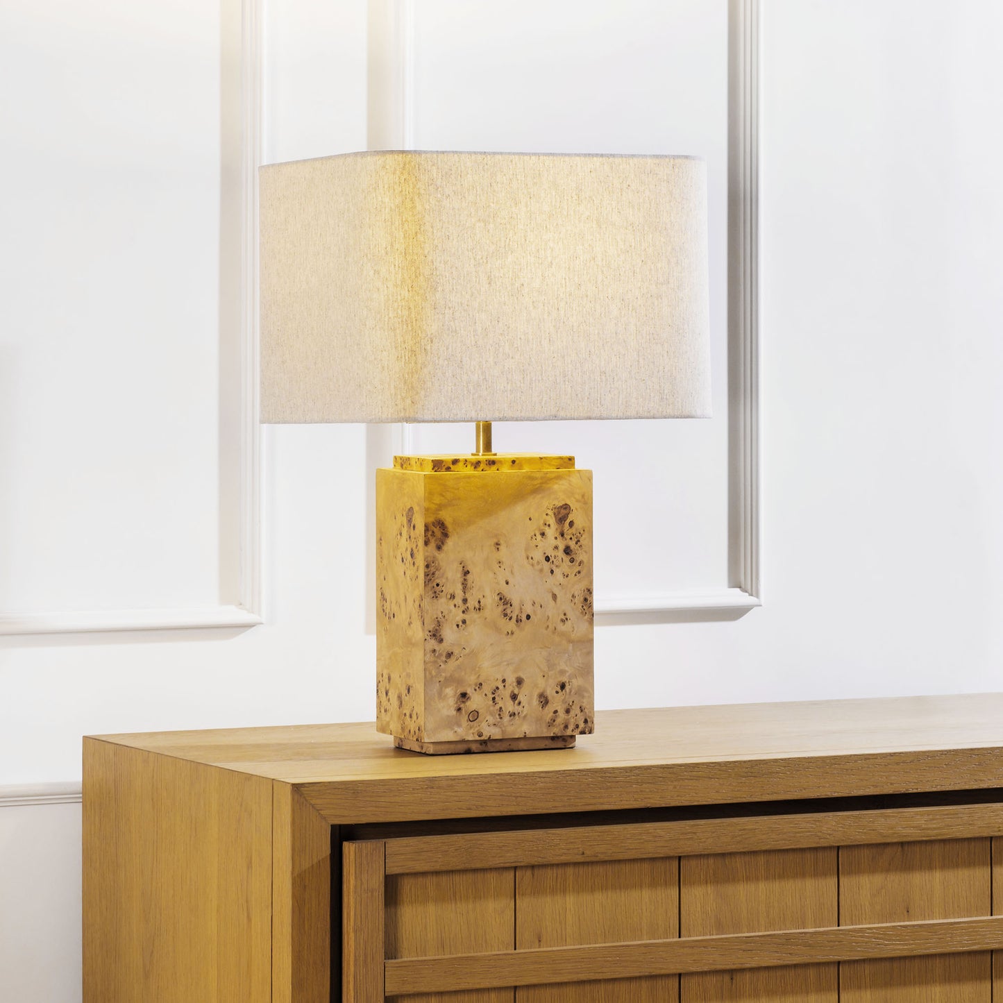 Burl wood table lamp stylized on sideboard table in living room.