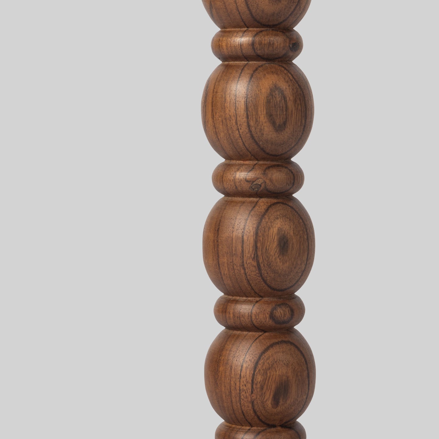 Round wooden side table with spindle design on a light gray background.