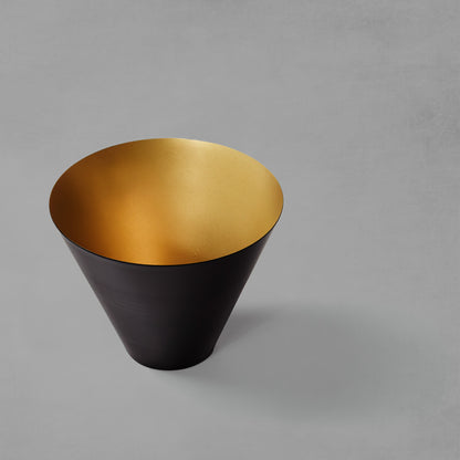 Medium decorative black and gold bowl with gray background.
