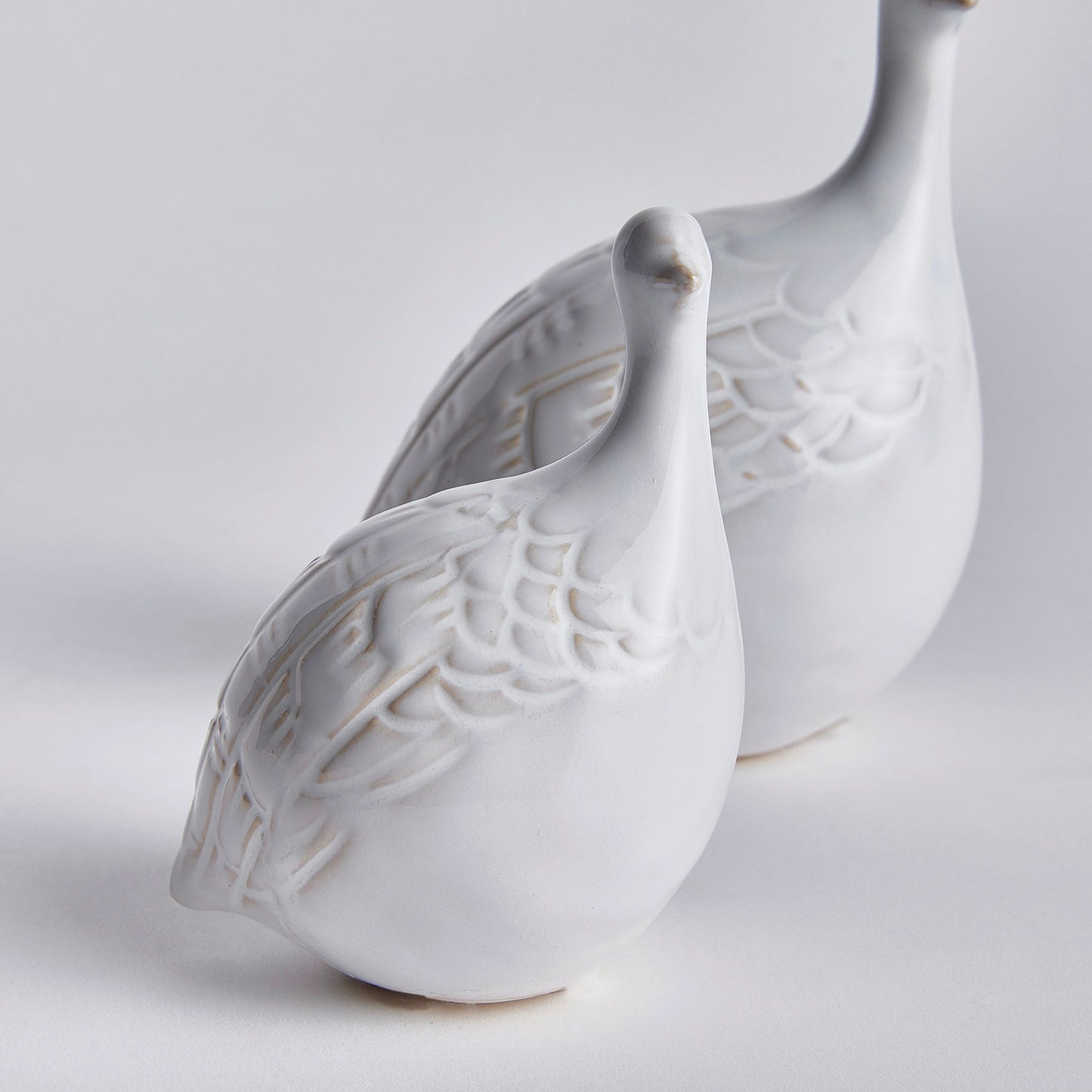 Decorative ceramic bird objects on white background closeup.