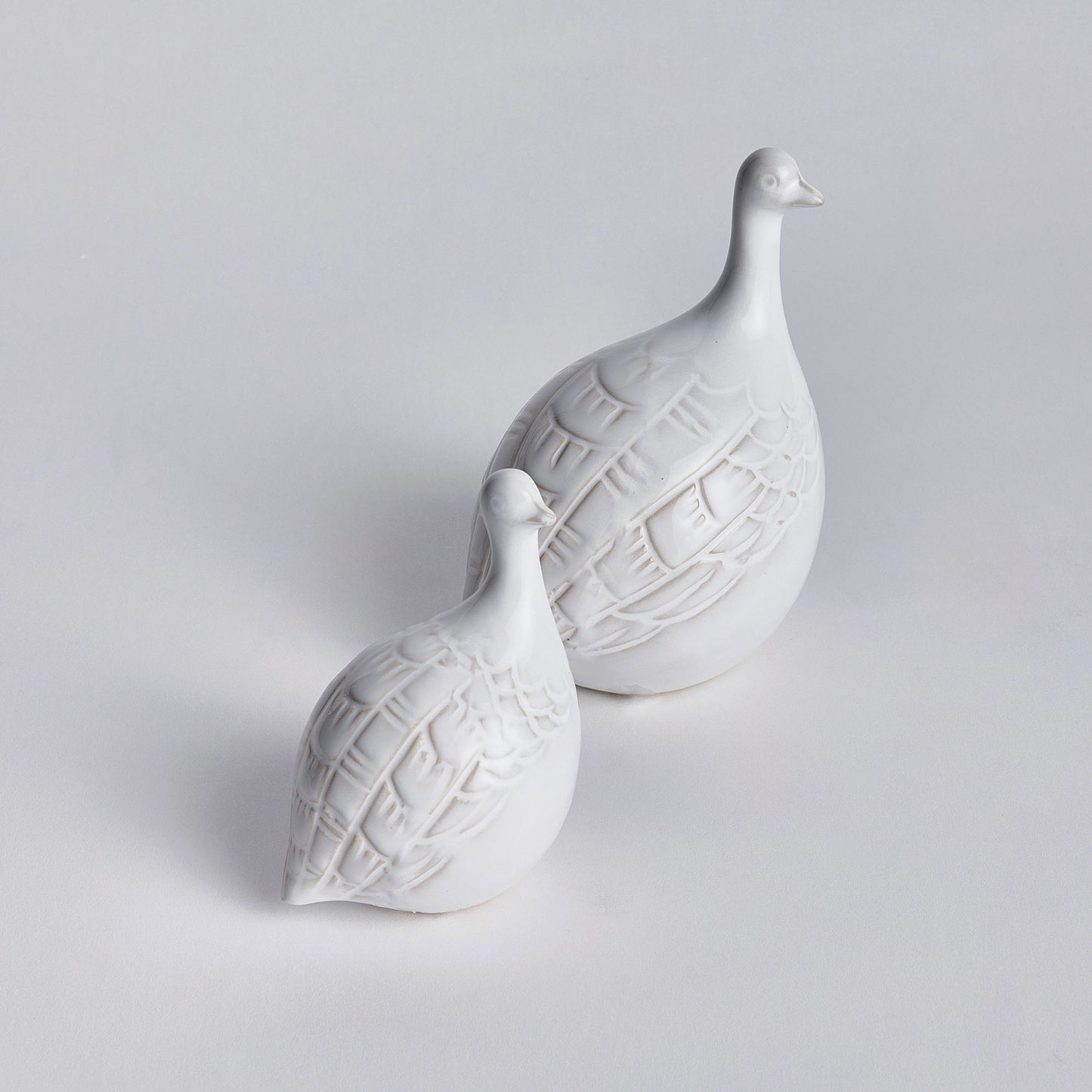 Decorative ceramic bird objects on white background.