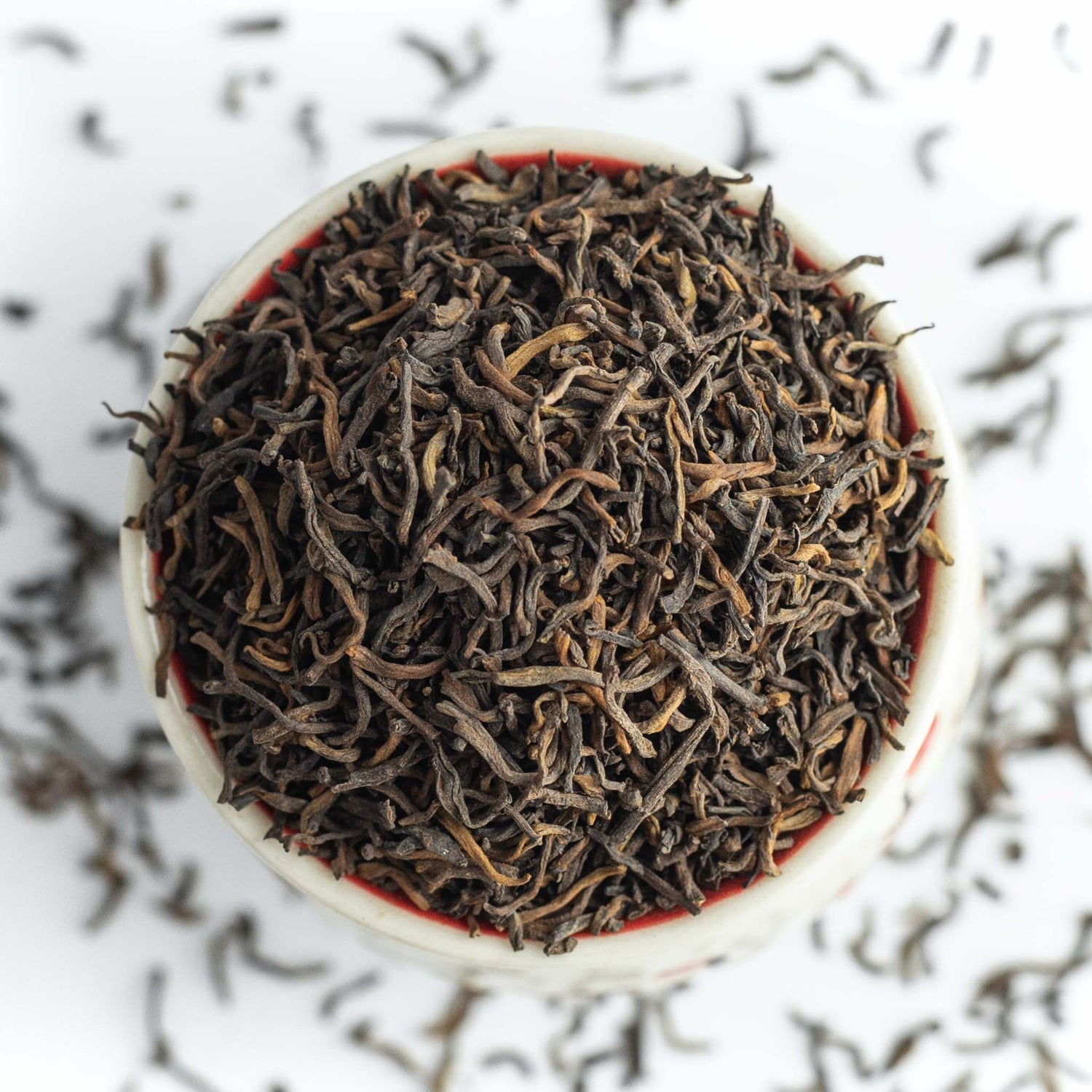 Dried tea leaves in white bowl.