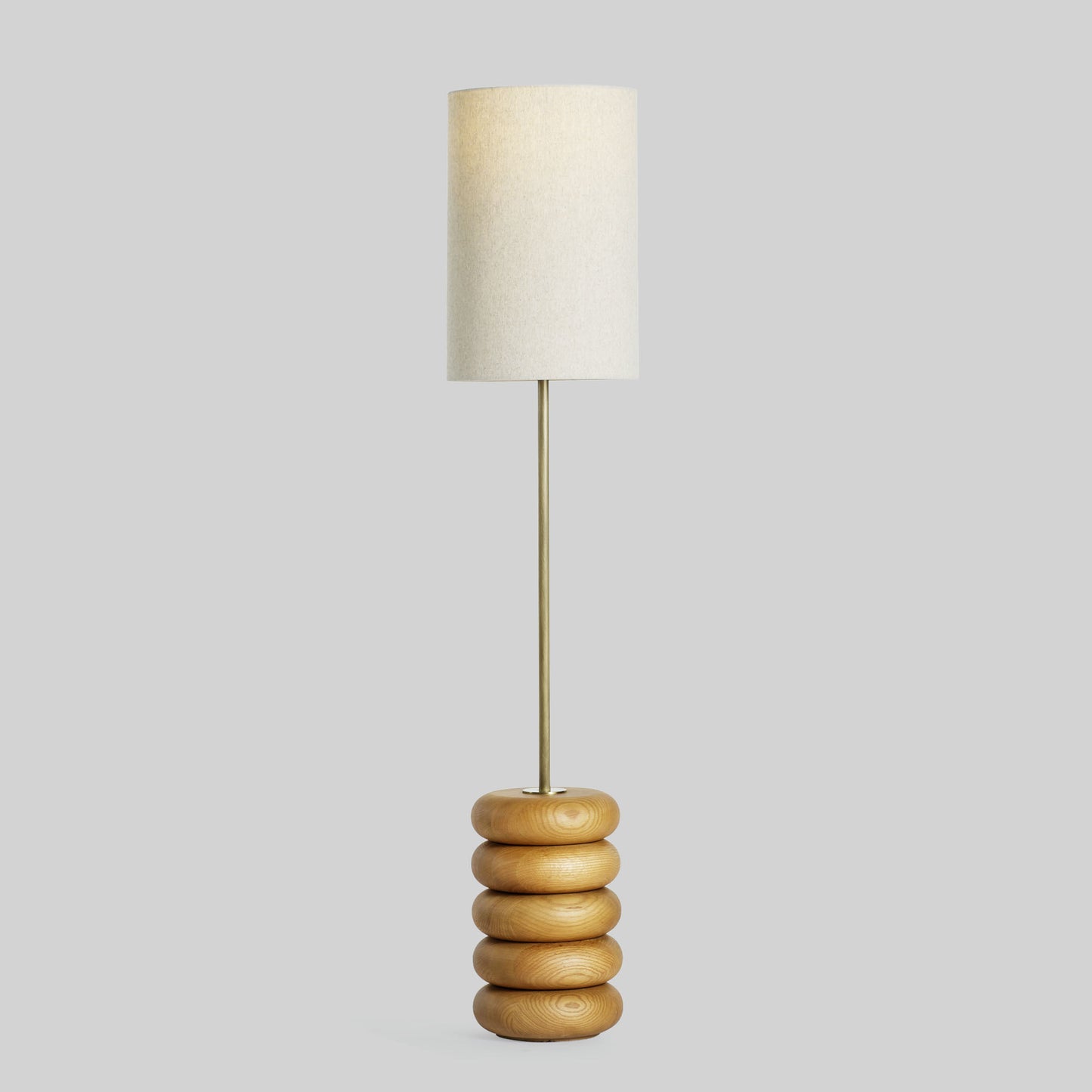 Floor lamp with a stacked circular wood base on a light gray background.