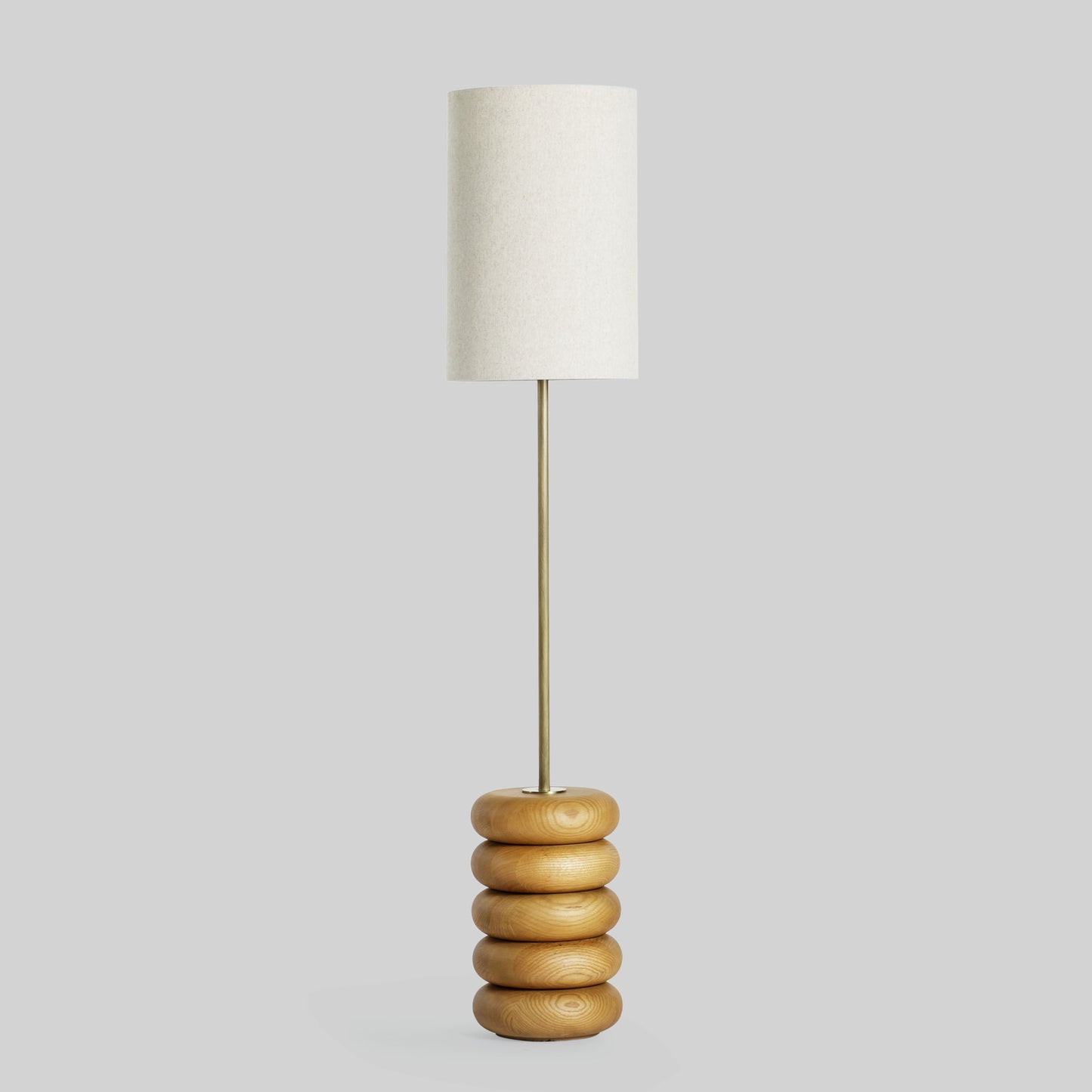 Floor lamp with a stacked circular wood base on a light gray background.