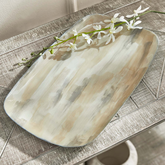 Enameled painted decorative metal tray, angled view, stylized on table.