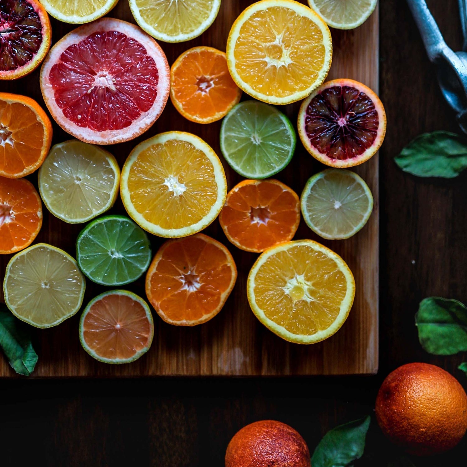 Fresh sliced citrus with dried sliced citrus on cutting board.