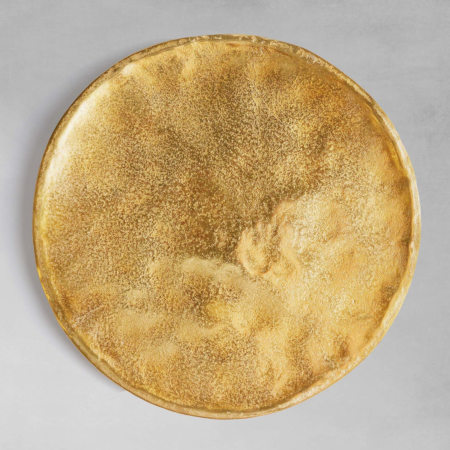 Gold round decorative tray, top view, with gray background.