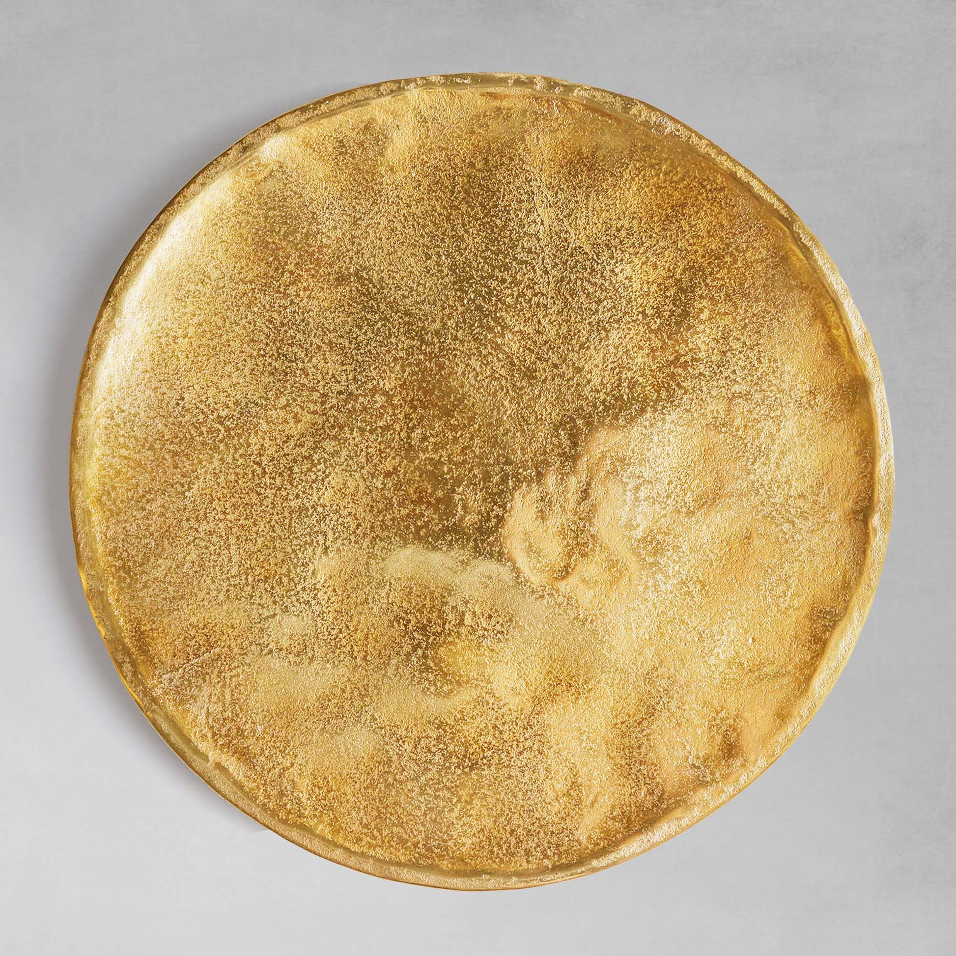 Gold round decorative tray, top view, with gray background.