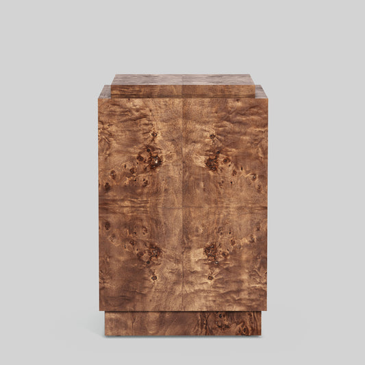 Dark burl wood plinth side table on gray background.