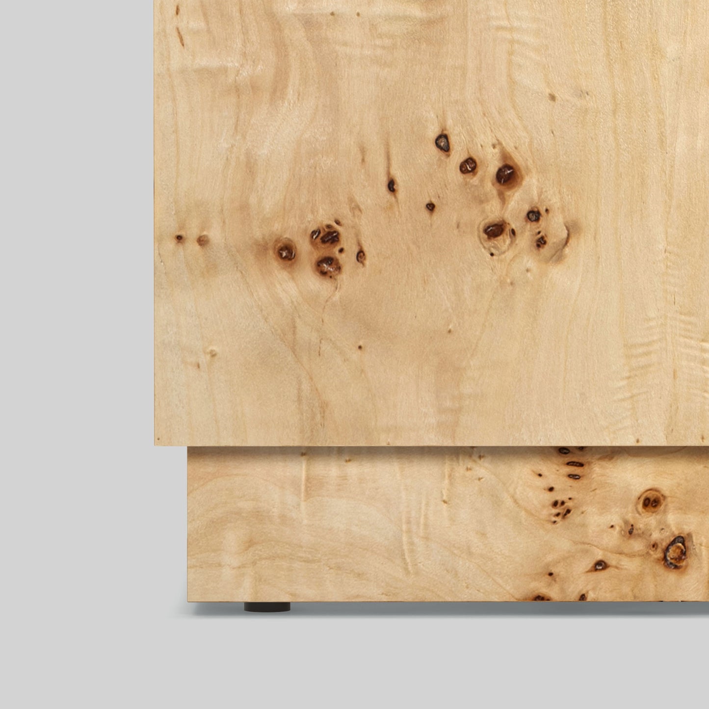 Light burl wood plinth side table on gray background.