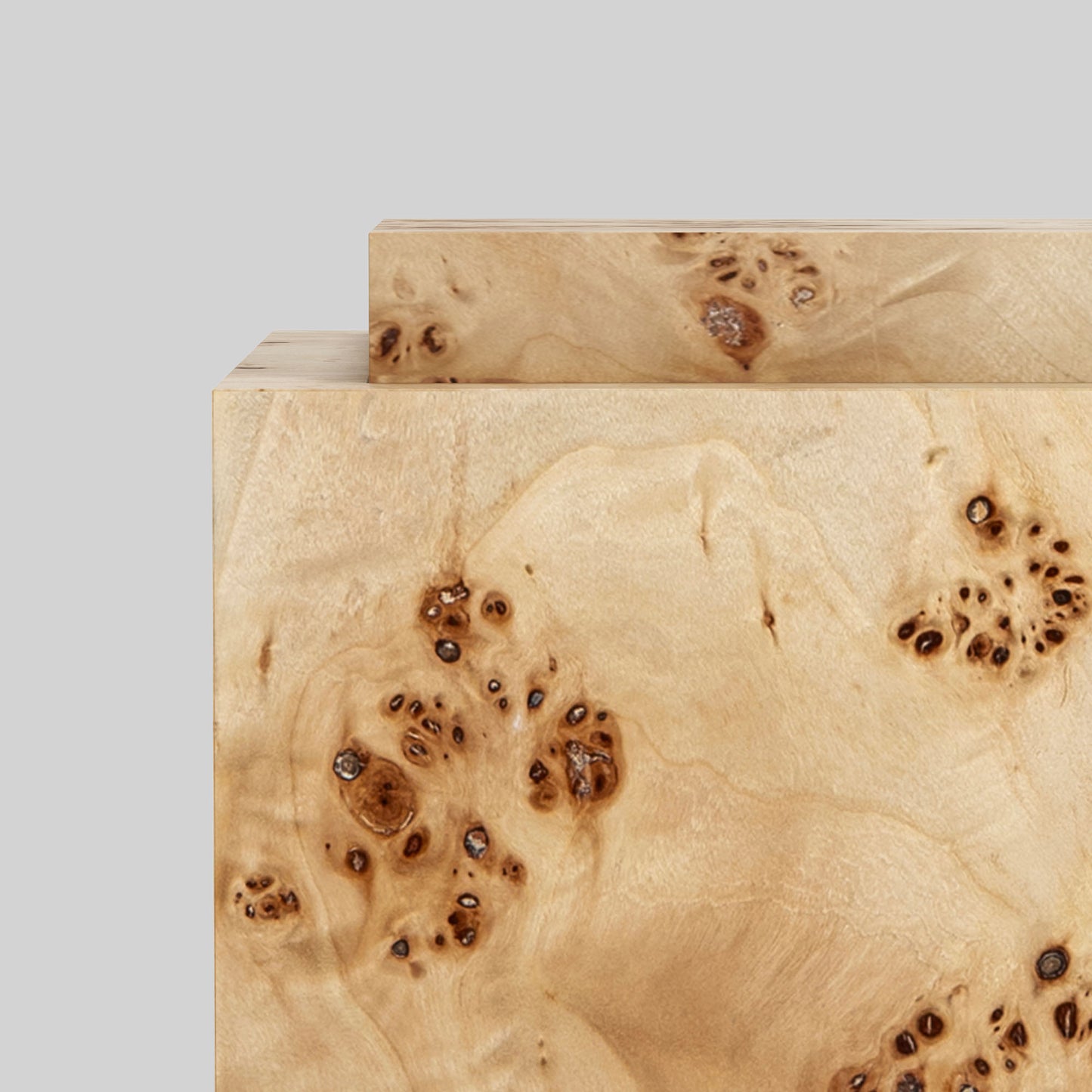 Light burl wood plinth side table on gray background.