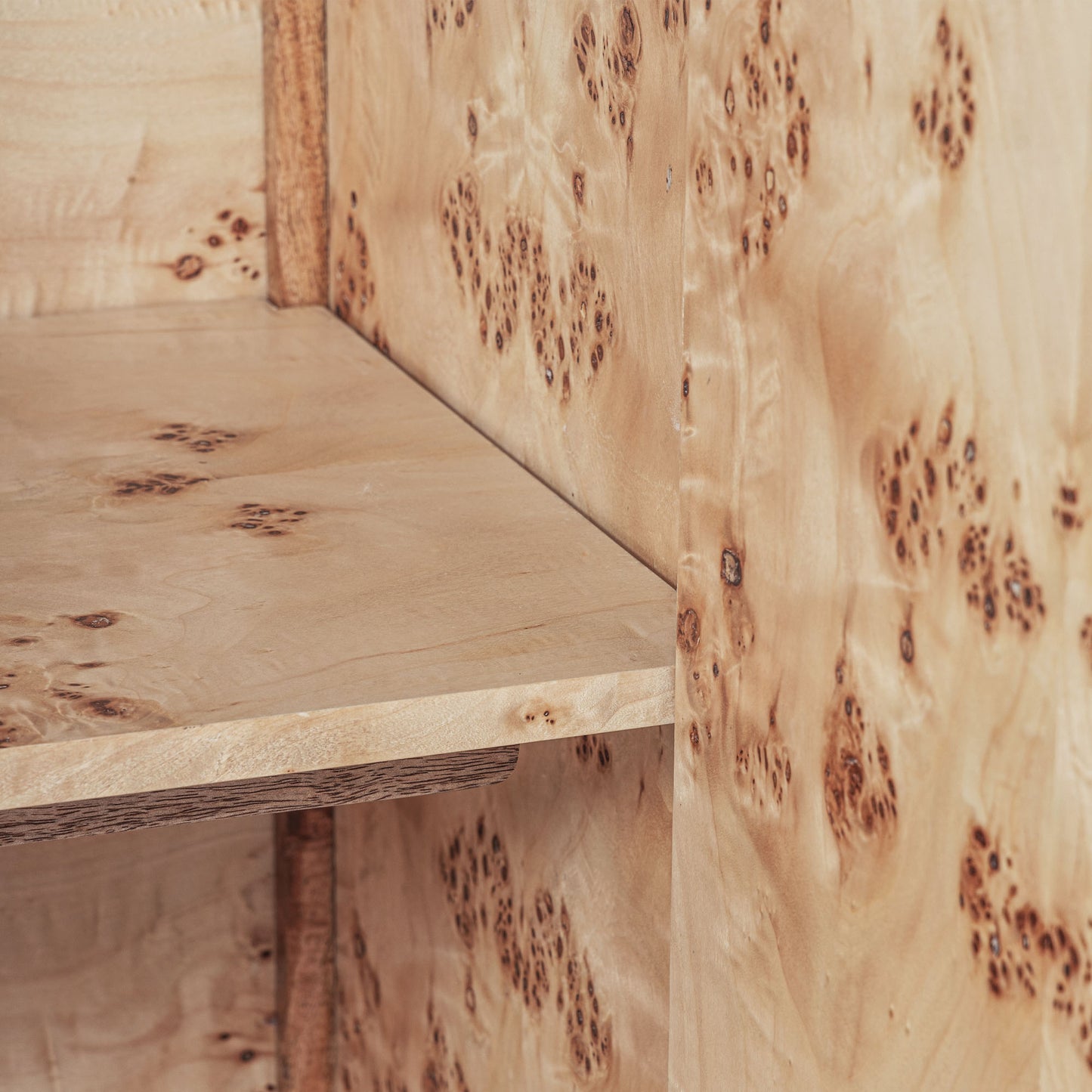 Light burl wood sideboard table on gray background.