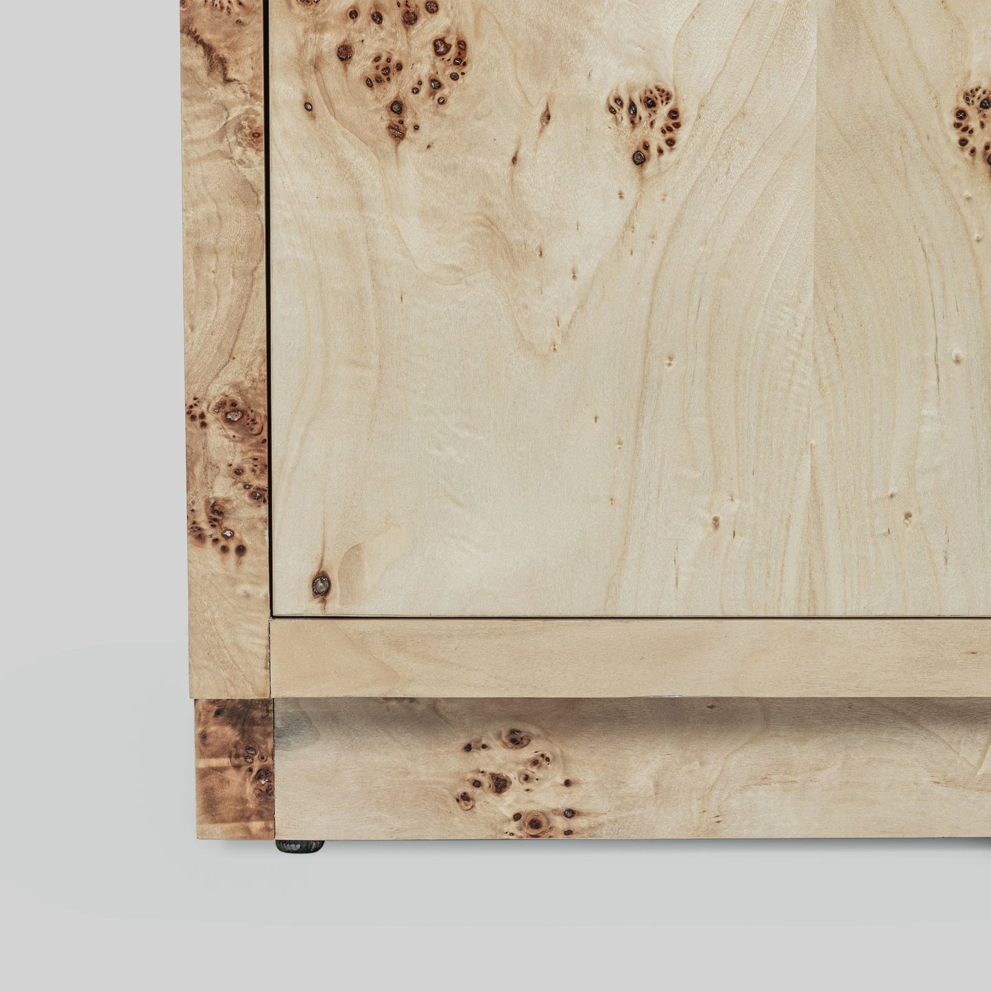 Light burl wood sideboard table on gray background.