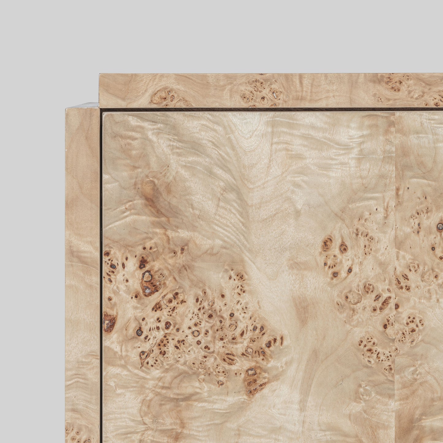 Light burl wood sideboard on gray background.
