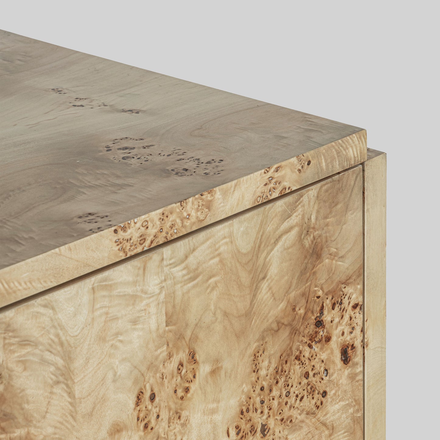 Light burl wood sideboard on gray background.