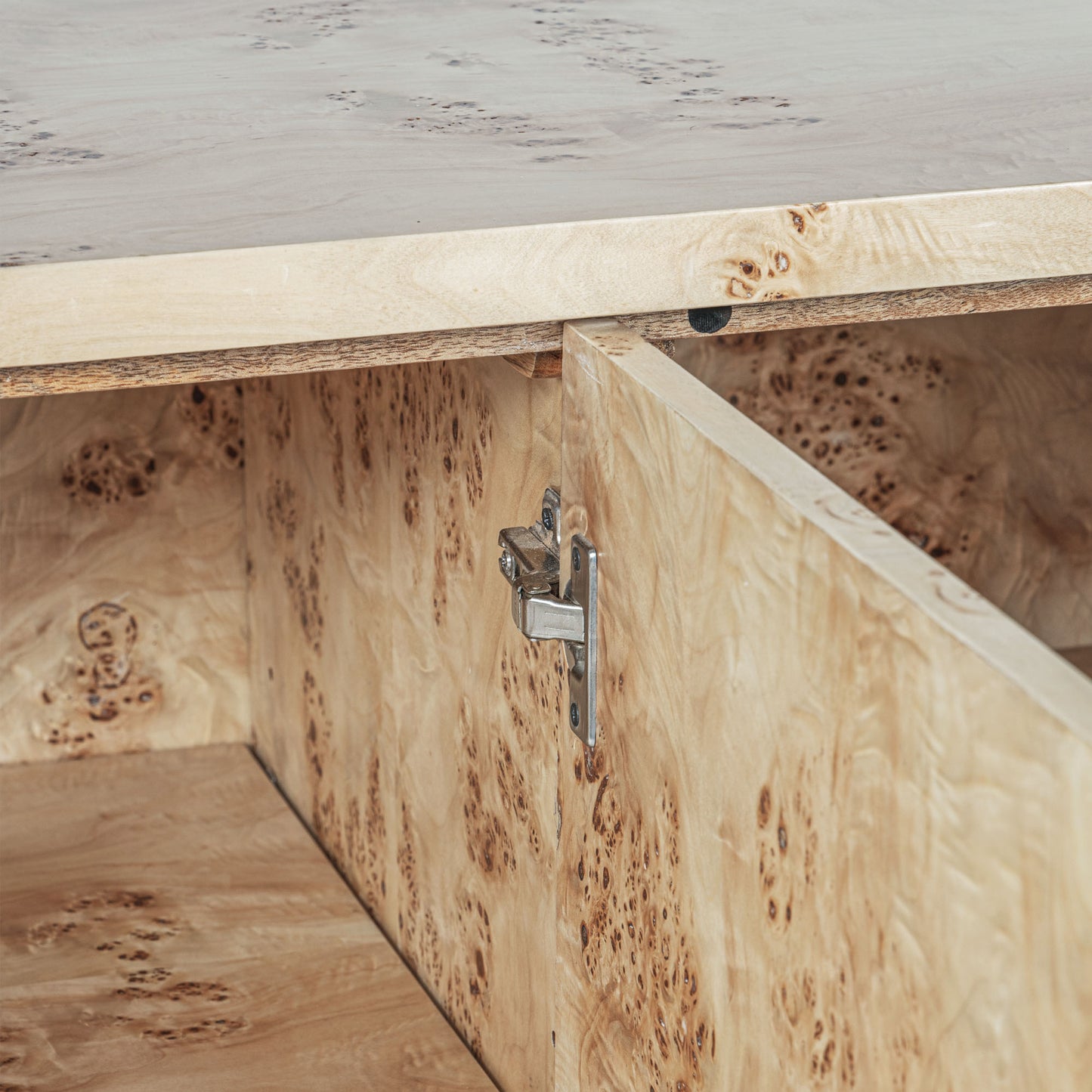 Light burl wood sideboard on gray background.