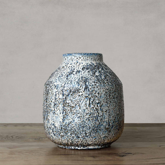 Handcrafted ceramic vase with rough textured surface with white, brown, and blue glazing.