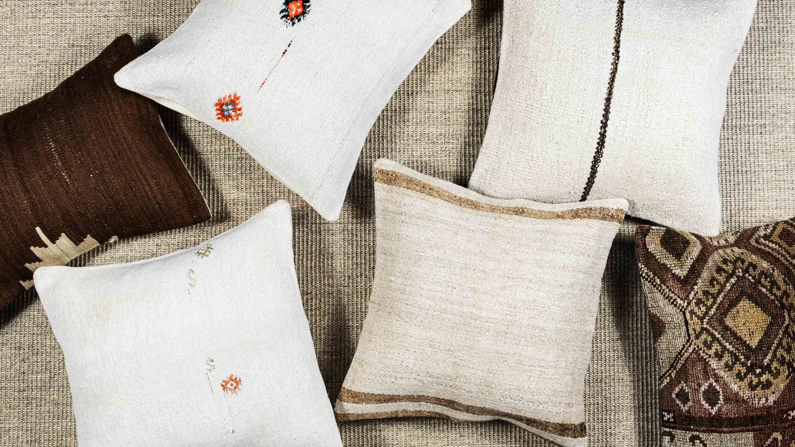 Handwoven turkish kilim pillow covers on sand colored neutral rug.