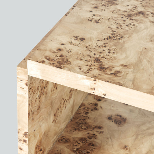 Light burl wood side table on gray background.