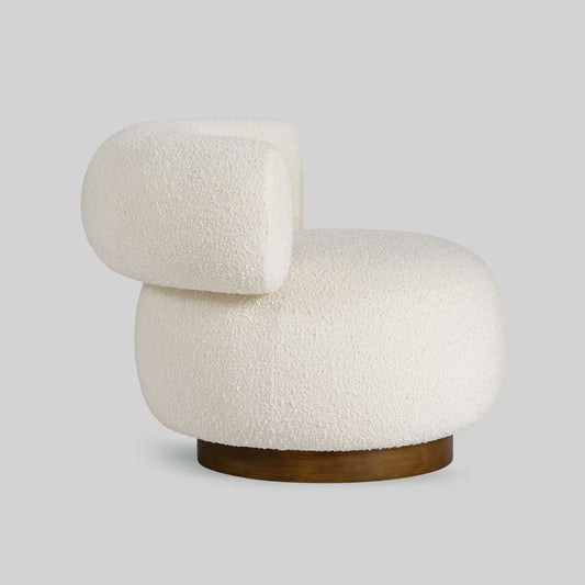 Light colored boucle fabric swivel chair on gray background.