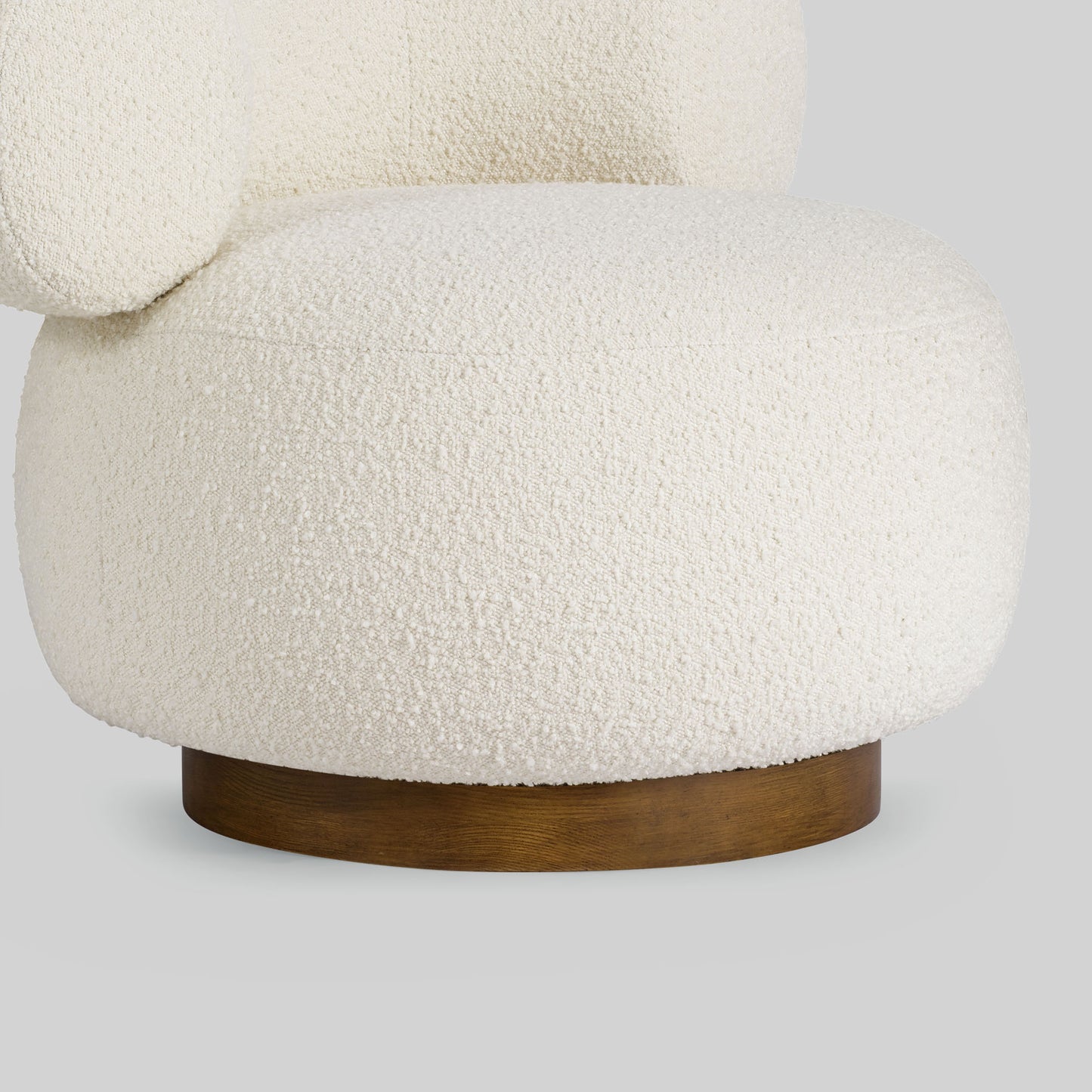 Light colored boucle fabric swivel chair on gray background.
