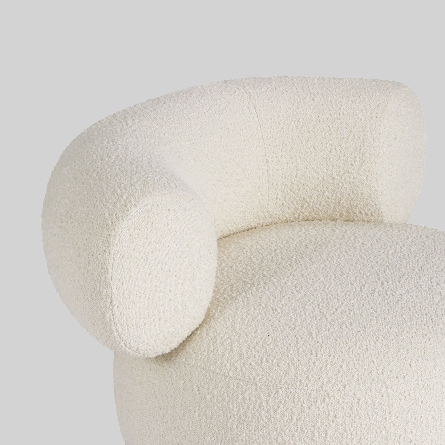 Light colored boucle fabric swivel chair on gray background.