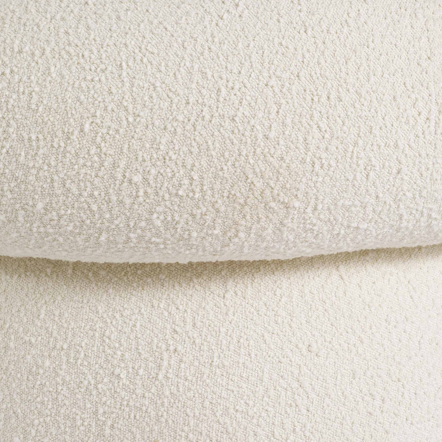 Light colored boucle fabric swivel chair on gray background.