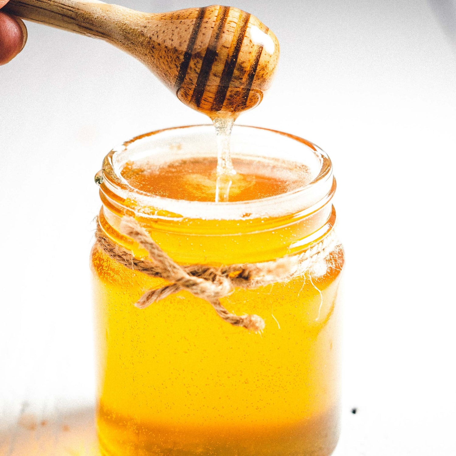 Honey dipped out of glass jar.