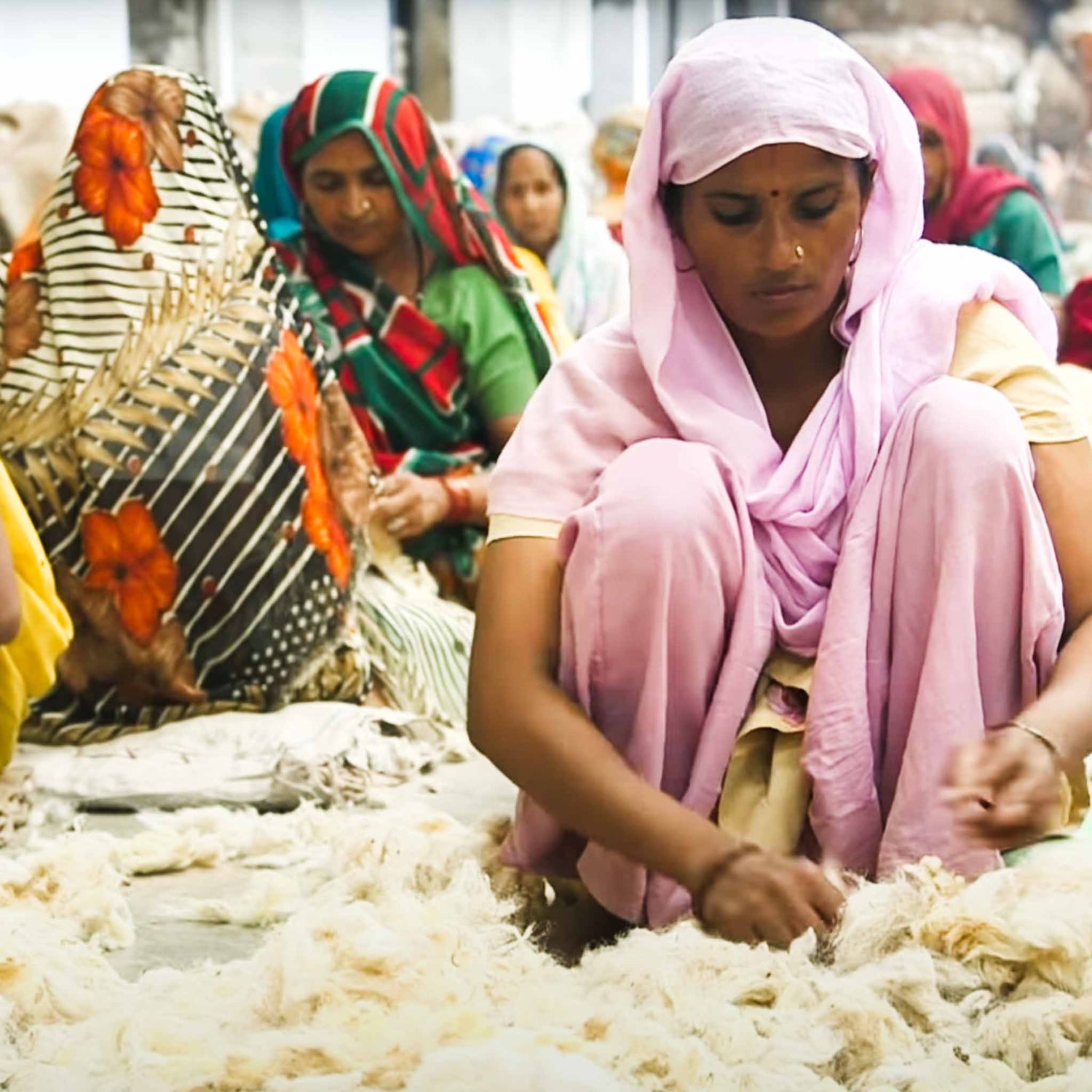 Indian women sorting textile material.