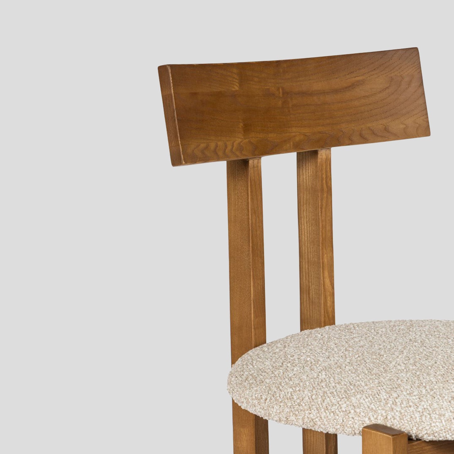 Wooden chair with a beige cushion on a light gray background