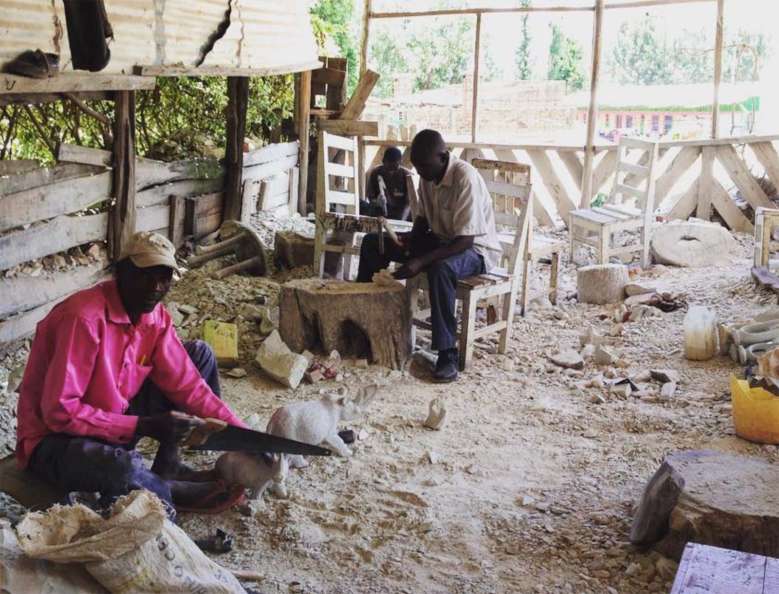 Kenyan men carving objects.