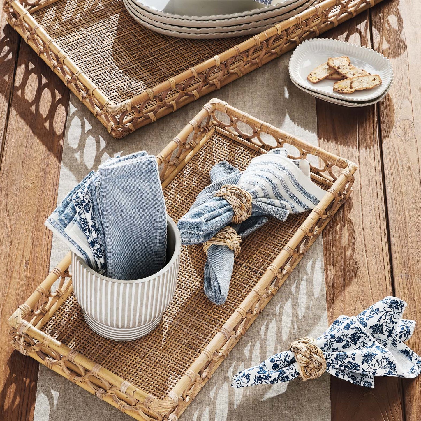 Lattice rectangular rattan serving trays stylized on outdoor dining table.