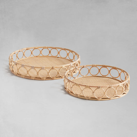 Lattice round rattan serving trays with gray background.