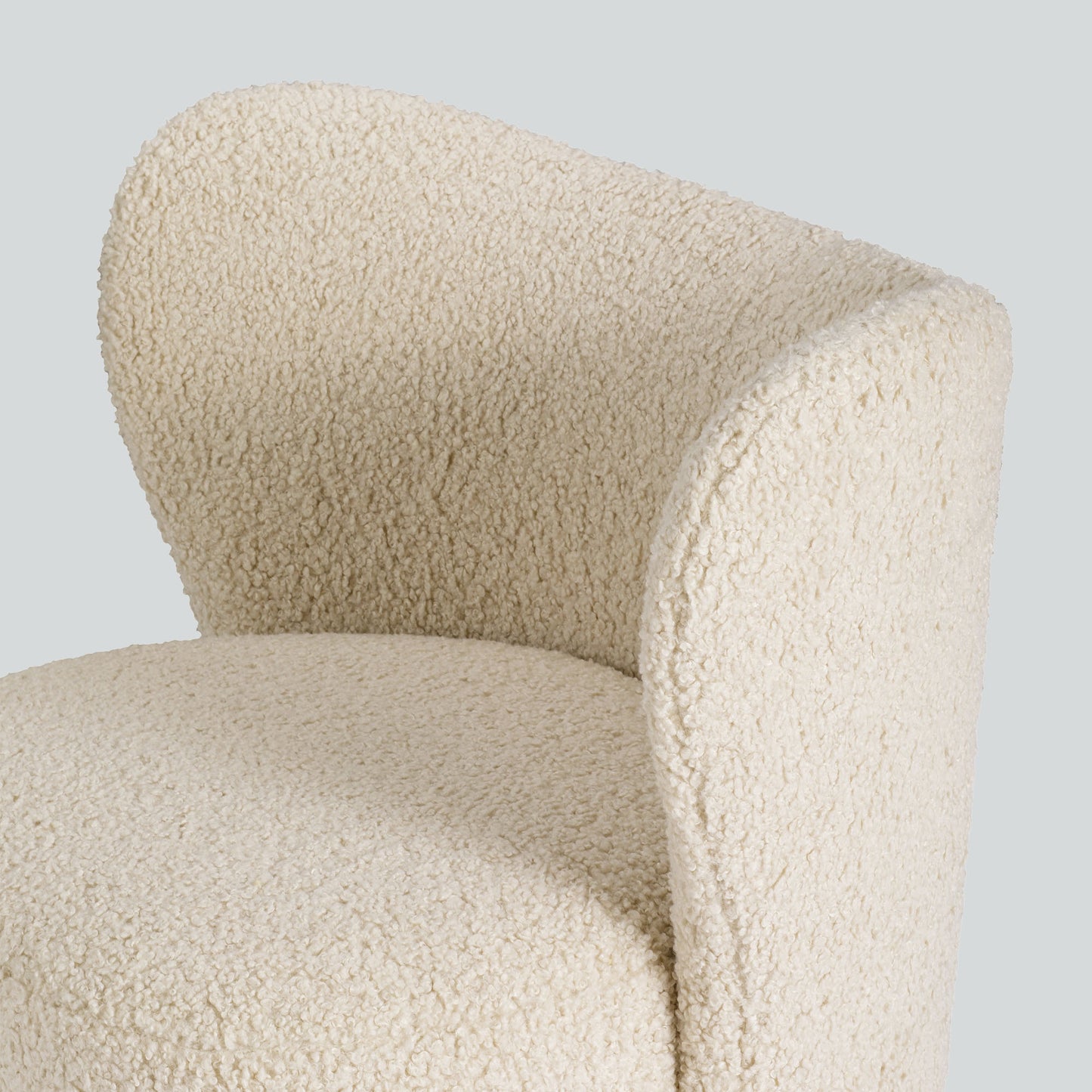 Cream toned sherpa fabric textured lounge chair on gray background.