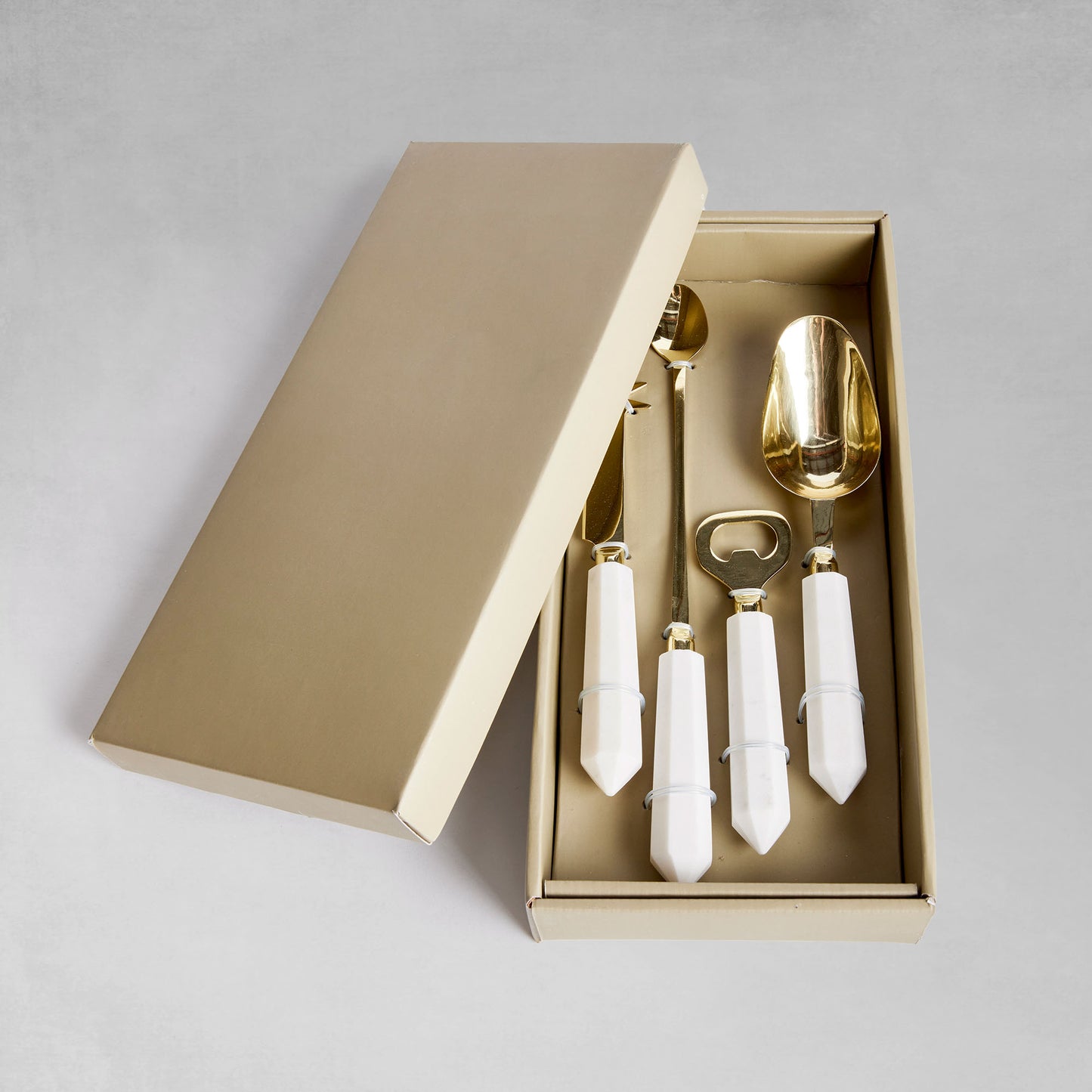 Marble and gold stainless steel barware tools set in box with gray background.