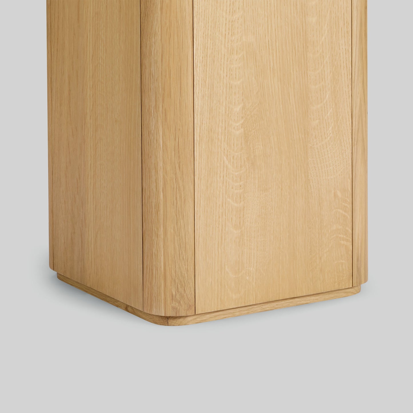 Wooden side table with a light oak finish and travertine top on a gray background.