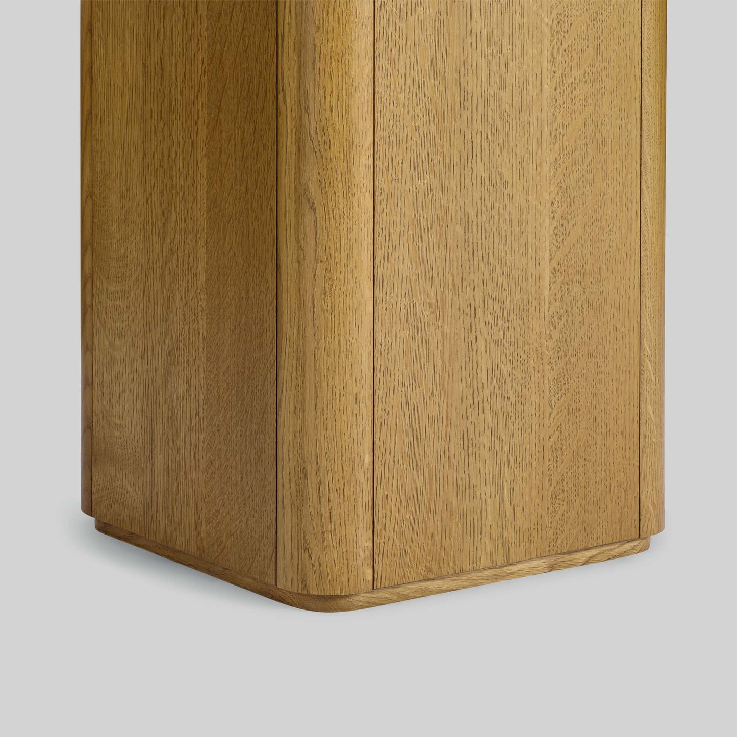 Wooden side table with a light finish and travertine top on a gray background.
