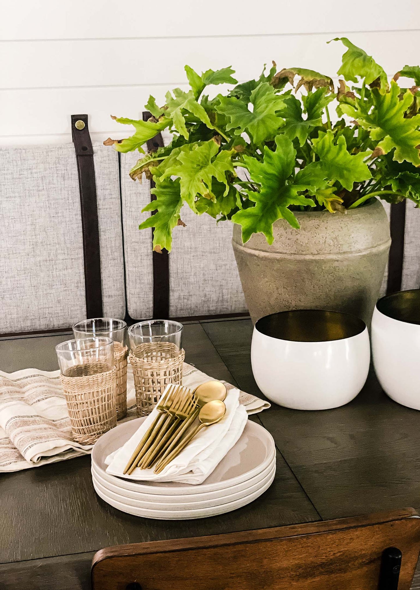 decorative white bowl with antique brass with brushed gold flatware stylized on table.