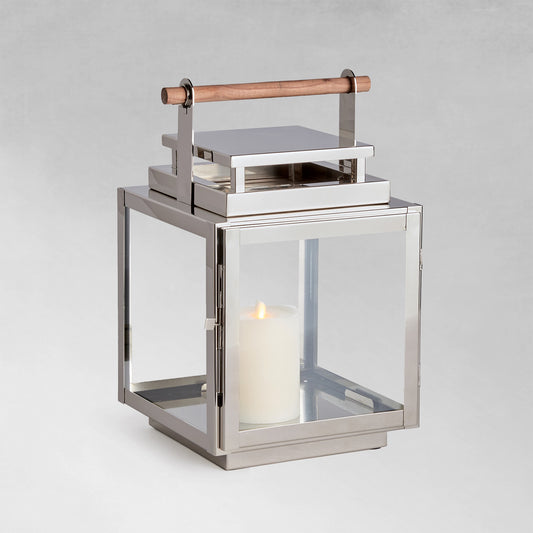 Medium metal outdoor lantern with chrome finish with gray background.