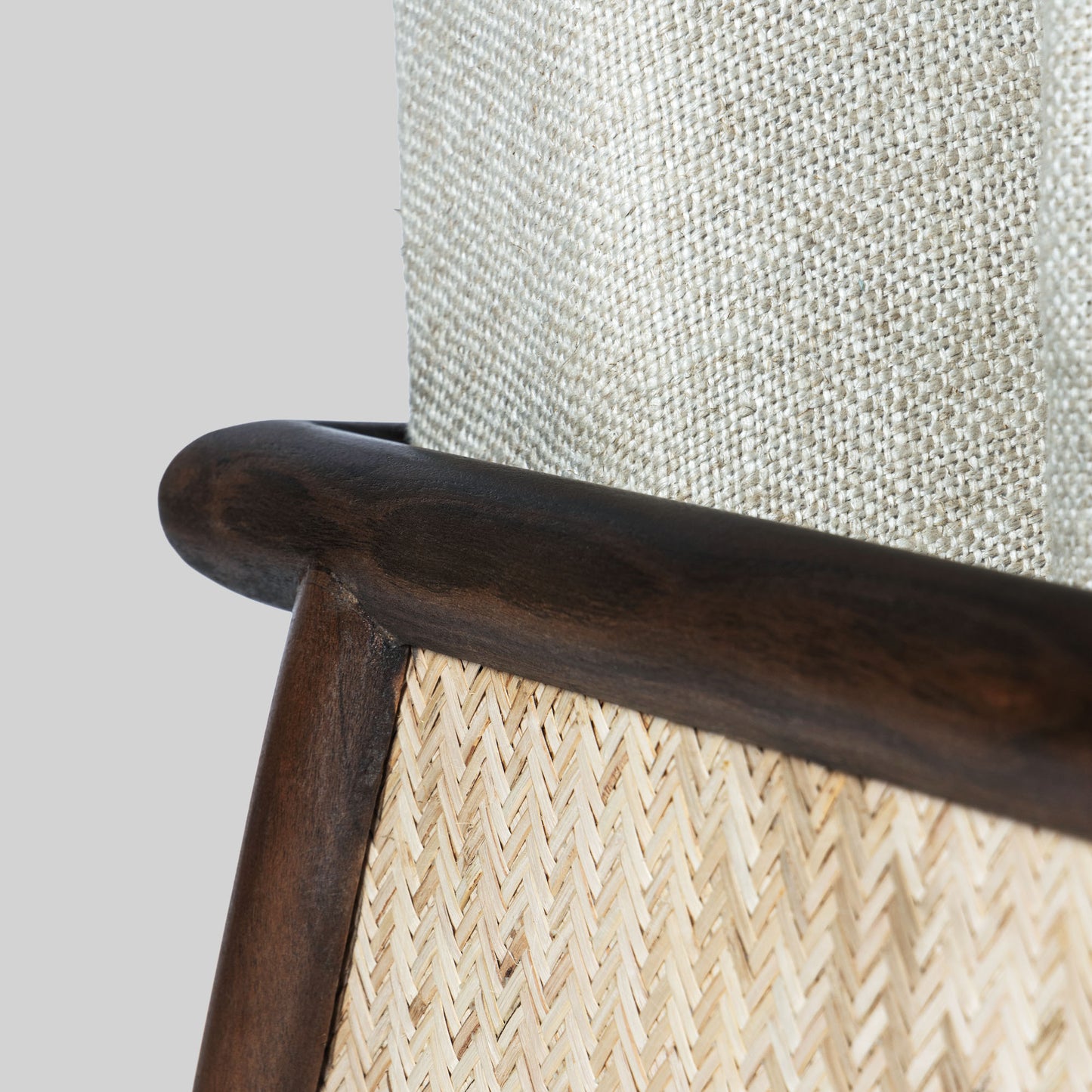 Beige armchair with cane arms and wooden frame on a light gray background.