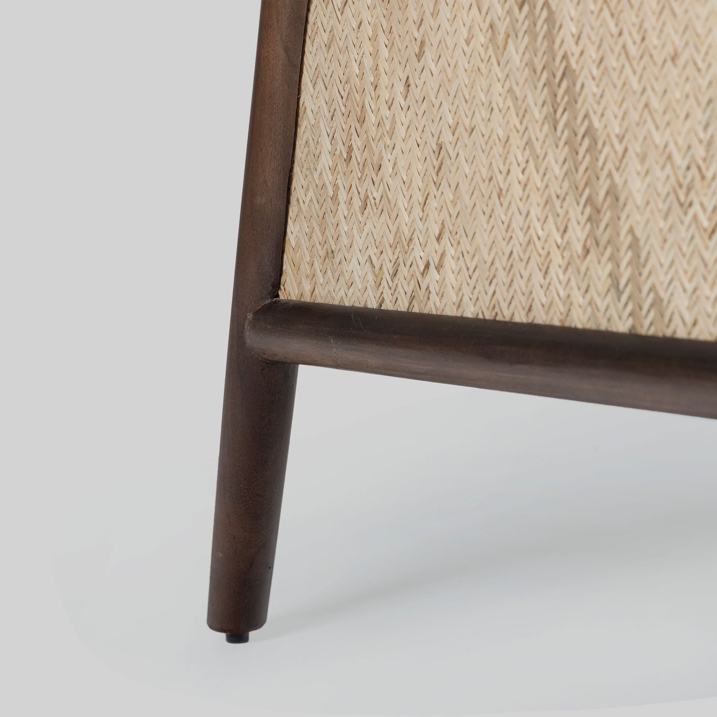 Beige armchair with cane arms and wooden frame on a light gray background.