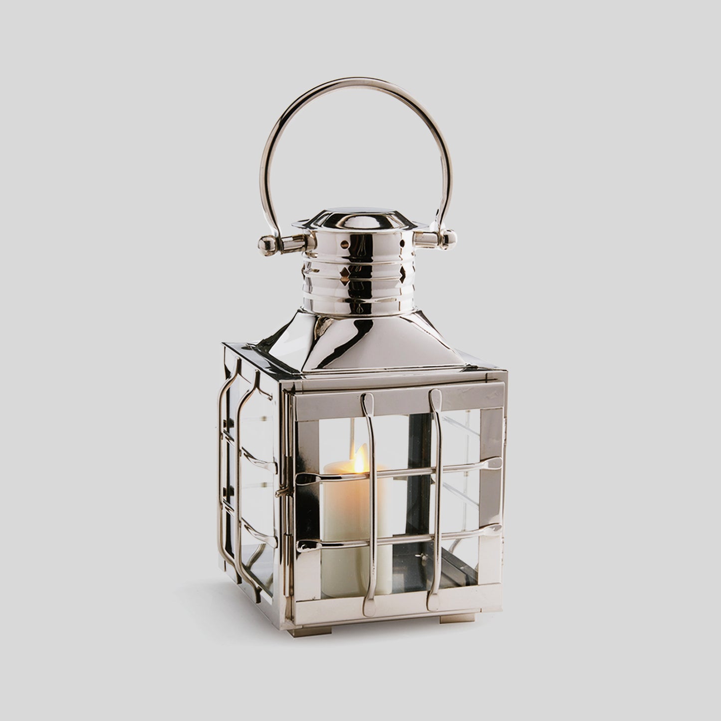 Nautical polished metal outdoor lantern in small size with gray background.