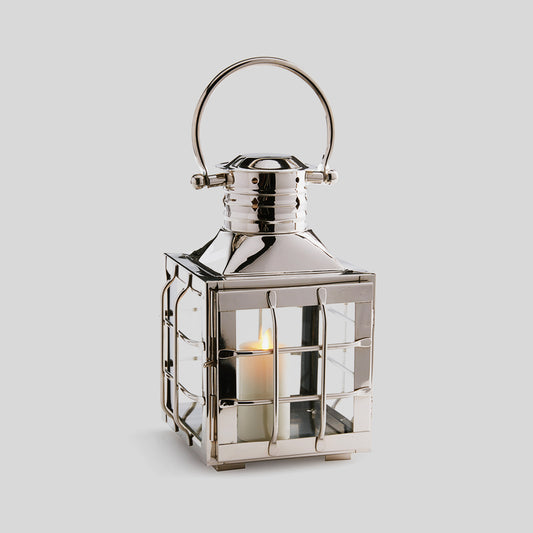 Nautical polished metal outdoor lantern in small size  with gray background.