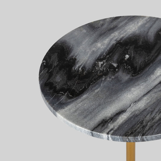 Small round cocktail table with marble top and brass base on a light gray background.